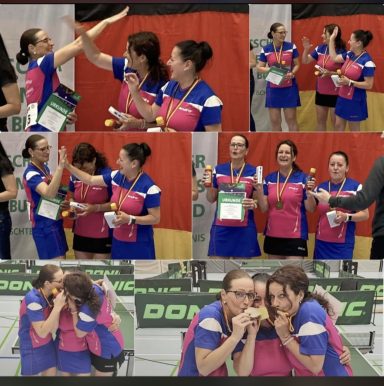 Zwei Frauen jubeln und feiern gemeinsam mit Medaillen und Pokalen in einem Sportumfeld.